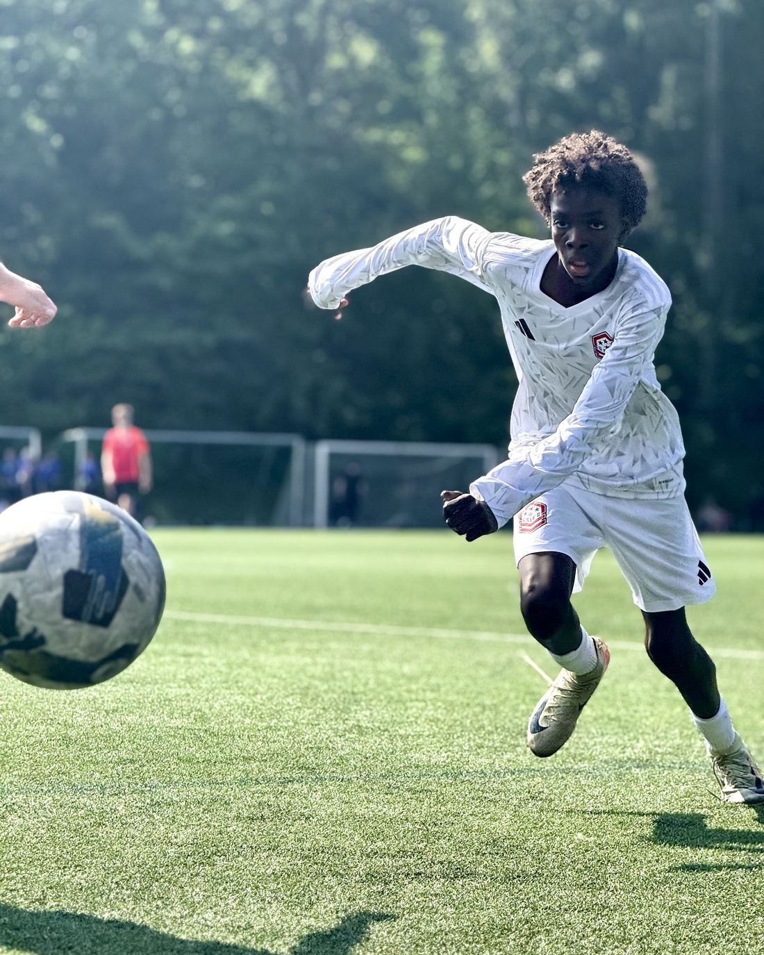 A USIFC player in white pushes the ball upfield